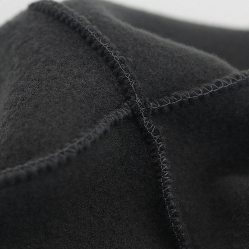 Close-up of black windproof fleece sports hat material, showing detailed stitching and soft fabric texture suitable for fishing and hunting.